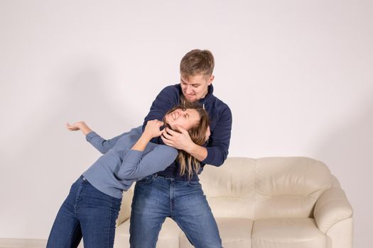 people, abuse and violence concept - agressive man strangling his wife.