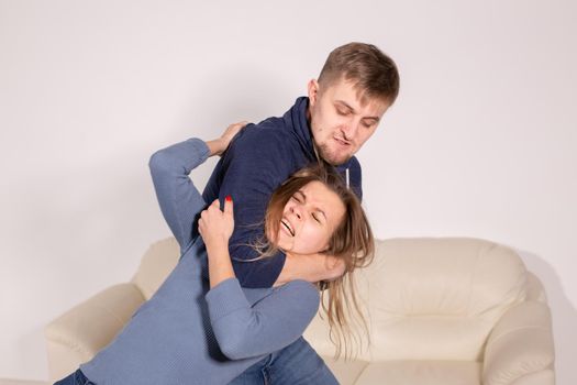 People, abuse and violence concept - aggressive man strangling his wife.