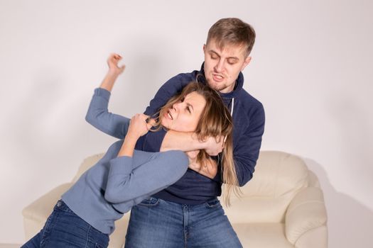 People, abuse and violence concept - aggressive man strangling his wife.