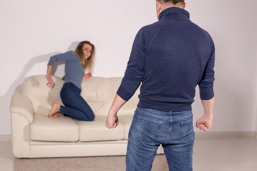 alcoholic, domestic violence and abuse concept - man gets drunk at home and takes his anger at his wife.