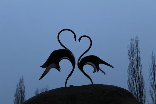 two swans stand on a heart-shaped stone. Mother's Day card, Valentine's Day Valentine's Day.