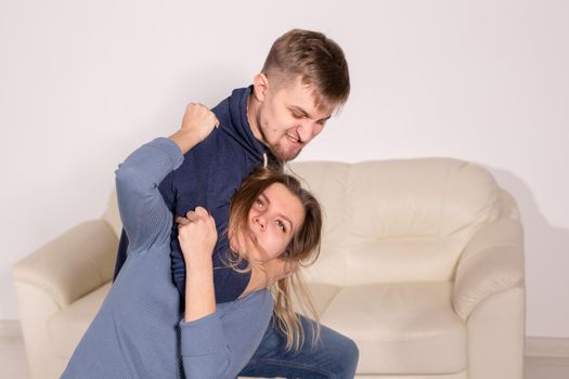 People, abuse and violence concept - aggressive man strangling his wife.