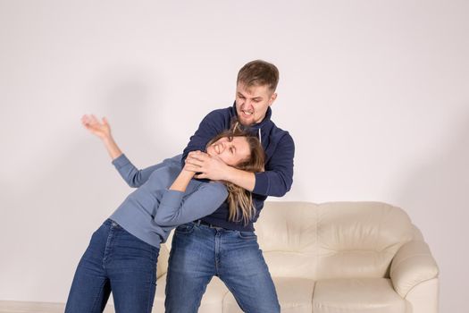 people, abuse and violence concept - agressive man strangling his wife.