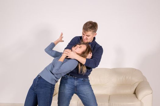 people, abuse and violence concept - agressive man strangling his wife.