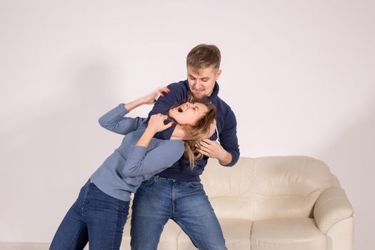 people, abuse and violence concept - agressive man strangling his wife.