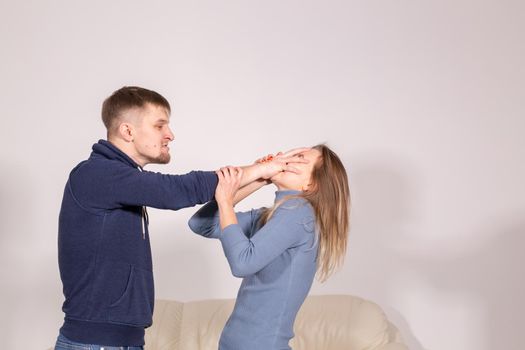 People and abuse concept - Portrait of angry young man try to hit the woman.