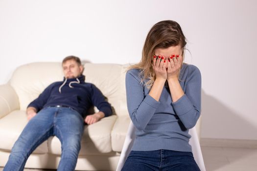 domestic violence, abuse and family concept - crying woman and her husband on the background.