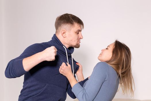 People and abuse concept - Portrait of angry young man try to hit the woman.