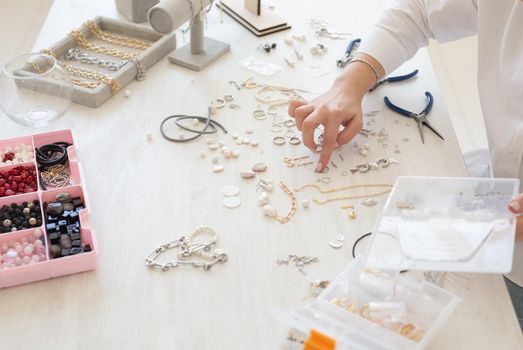 Professional jewelry designer making handmade jewelry in studio workshop. Fashion, creativity and handmade concept.