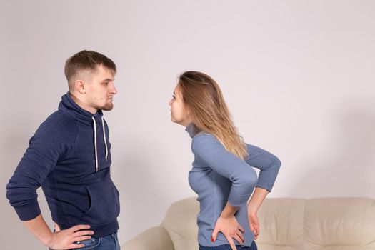 people, domestic violence and abuse concept - young couple arguing indoors.