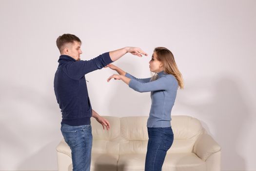 people, violence and abuse concept - angry man hitting woman in her face on sofa.