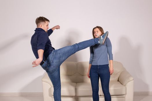 People, violence and abuse concept - man beating helpless woman at home background.