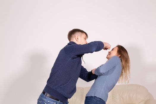 People and abuse concept - Portrait of angry young man try to hit the woman.