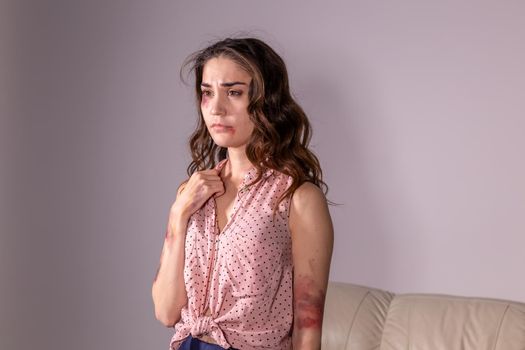 violence issues - Woman victim of domestic violence and abuse over grey background.