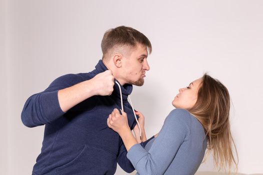 People and abuse concept - Portrait of angry young man try to hit the woman.