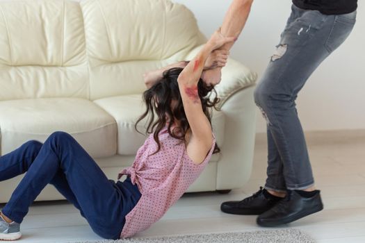 domestic violence, alcoholic and abuse concept - aggressive man grabbing his wife lying on the floor.