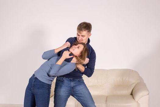 people, abuse and violence concept - agressive man strangling his wife.