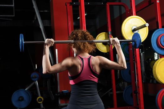 Woman bodybuilder engaged with a barbell in the gym. Healthy lifestyle.