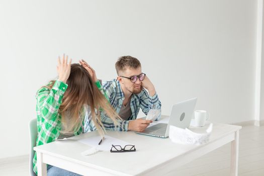 Husband and wife discuss amount in check for payment of the apartment and compare it with the rates on official website while sitting at the table with laptop. Concept of payment of utility bills