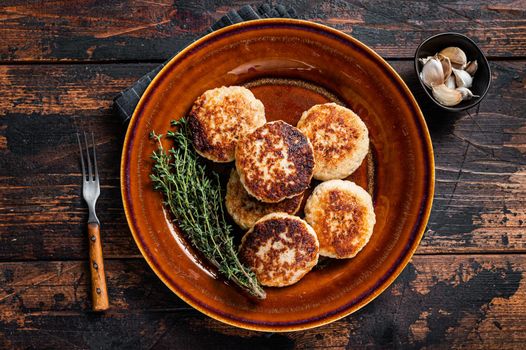 Fried pork and beef meat cutlets or patty in a rustic plate. Dark wooden background. Top view.