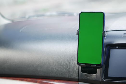 smart phone with green screen on car dashboard .
