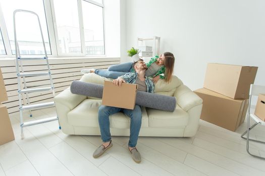 Cheerful young couple rejoices in moving to a new home laying out their belongings in the living room. Concept of housewarming and mortgages for a young family.