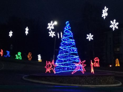 Christmas illumination Christmas tree carriage fountain white blue on dark background.