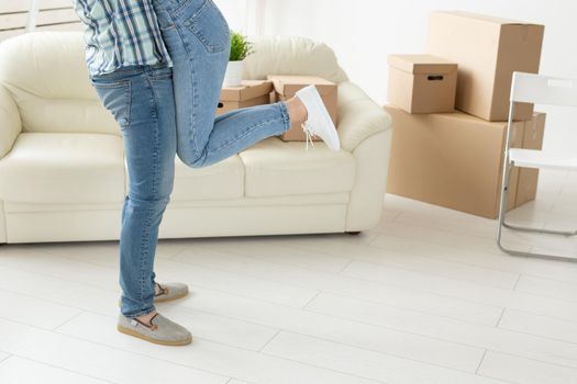 Unidentified young couple in denim pants embracing rejoicing in their new apartment during the move. The concept of housewarming and credit for new housing