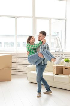 Loving young couple embracing rejoicing in moving to their new home. The concept of moving and housewarming of young family