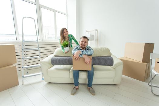 Cheerful young couple rejoices in moving to a new home laying out their belongings in the living room. Concept of housewarming and mortgages for a young family.