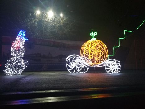 Christmas illumination Christmas tree carriage fountain white blue on dark background.