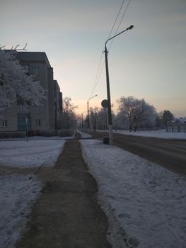 winter cityscape. road with snow trees and houses new year Christmas on the street.