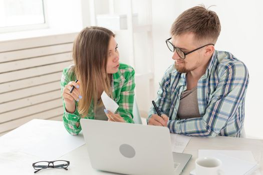 Dissatisfied young husband and wife recount utility bills for payment of an apartment and write the results in a notebook