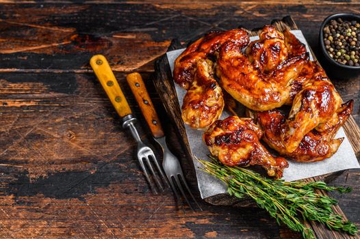 Baked Bbq chicken wings with dip sauce. Dark wooden background. Top view. Copy space.