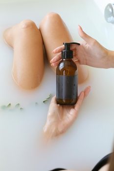 Woman's holding botles with spa cosmetics during bathrom time. Concept of Beauty blogger, salon therapy, minimalism concept, copyspace