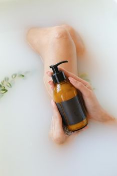 Woman's holding botles with spa cosmetics during bathrom time. Concept of Beauty blogger, salon therapy, minimalism concept, copyspace