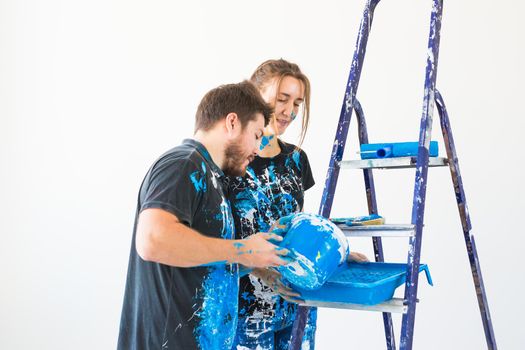 Repair, color, people concept - couple going to paint the wall, they are preparing the color.