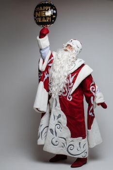 Santa Claus posing with festive balloon on gray studio background, xmas and new year celebration concept. High quality photo