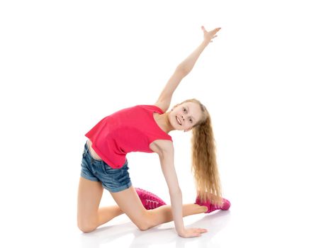 A girl gymnast performs an acrobatic element on the floor. The concept of childhood, sport, healthy lifestyle. Isolated on white background.