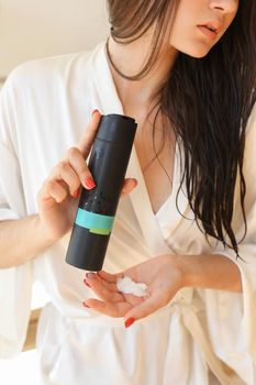 Woman holding botle or jar for spa cosmetics hair purpose in bathroom. Beauty blogger, salon therapy, minimalism concept, copyspace for your text