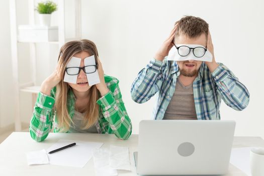 Young upset husband and wife were upset because of numerous expenses on paying for housing and communal services and repairing the apartment. covering their eyes with checks and ears with their hands