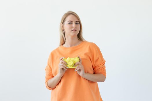 Photographer, hobby and leisure concept - Young blond woman with retro camera on white background with copy space.