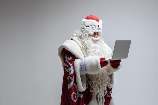 father frost with long beard do something with a laptop, picture isolated on grey background