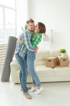 Loving young couple embracing rejoicing in moving to their new home. The concept of moving and housewarming of young family