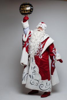 father frost with long beard holds a black christmas baloon, picture isolated on grey background