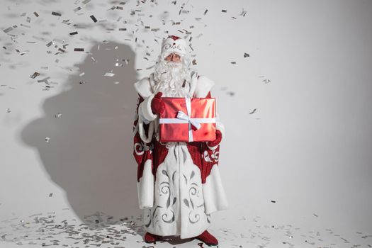 santa claus with long white beard with big red box with a christmas present in his hands, picture isolated on white background