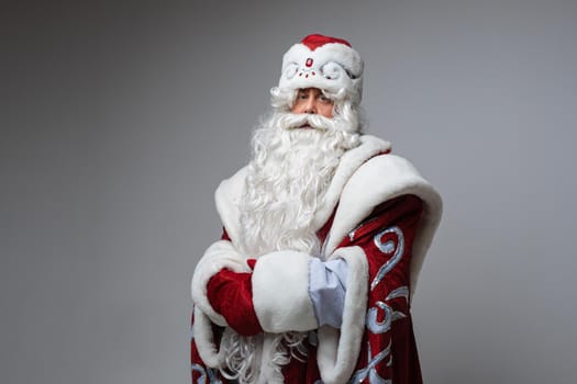 Tired Santa Claus posing on gray studio background with copy space for holiday xmas and new year advertising. High quality photo