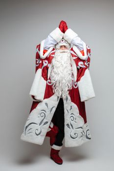 Stock photo of smiling happy Santa in traditional hat with rhinestones and long white beard looking at camera. Cutout on red background. Happiness concept.