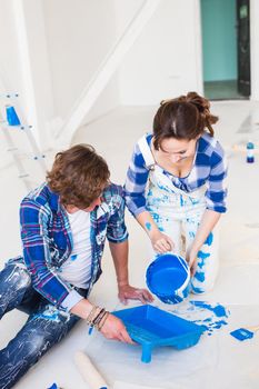 Repair, color, people concept- couple going to paint the wall, they are mixing the color.