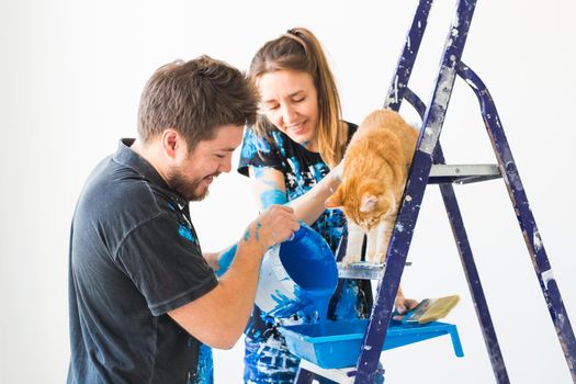 Repair, color, people concept - couple with cat going to paint the wall, they are preparing the color.